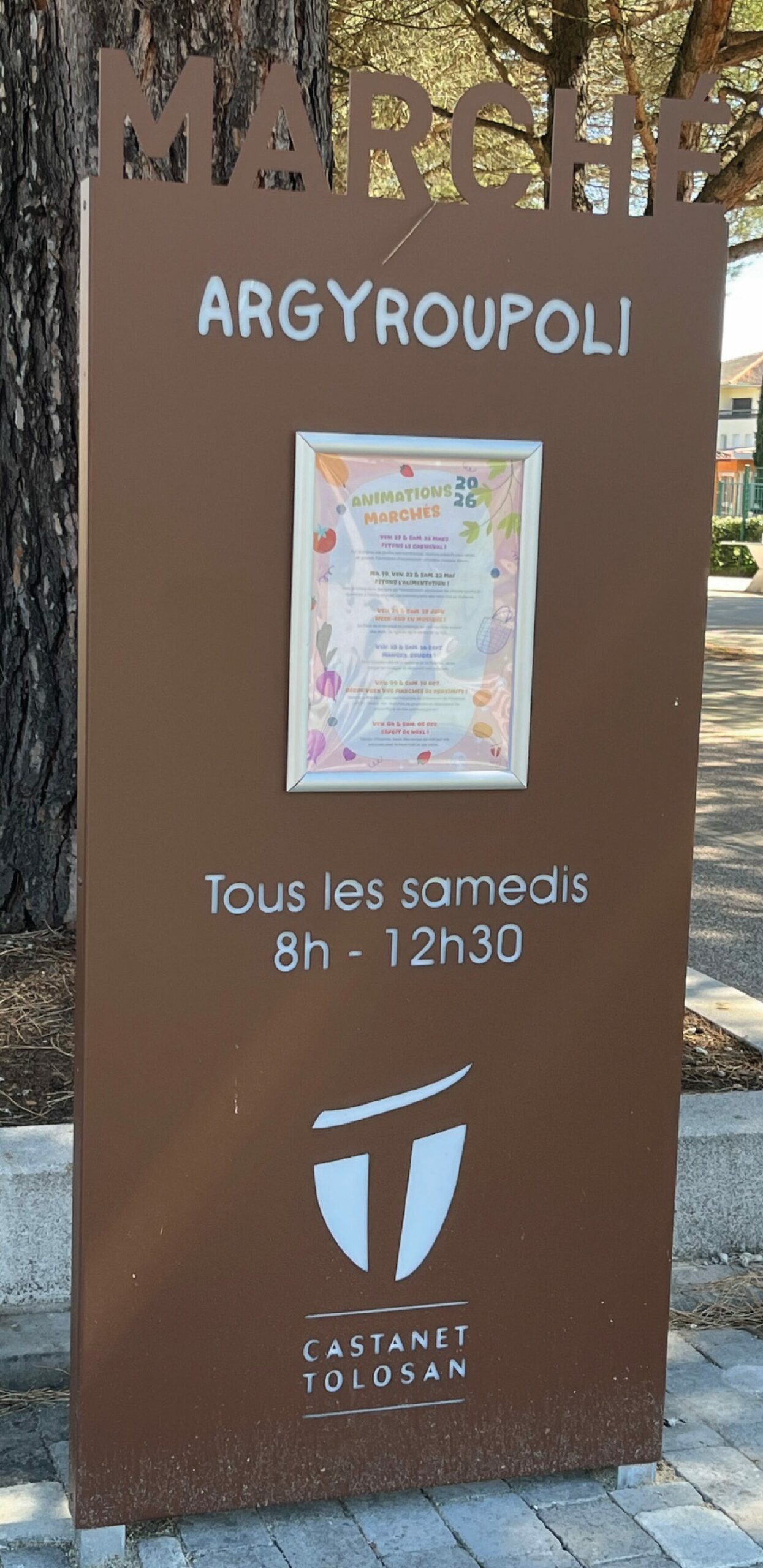 Totem signalétique en acier corten avec panneau d'affichage pour le marché d'Argyréoupoli à Castanet-Tolosan.
